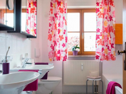 Einblick ins Badezimmer, hier die beiden Waschbecken mit Blick zum Fenster und den schönen frischen Gardienen