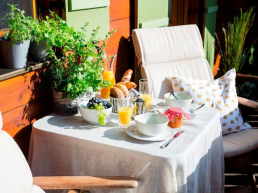 Blick auf den in der Sonne gedeckten Frühstückstisch der Ferienwohnung Waldidyll